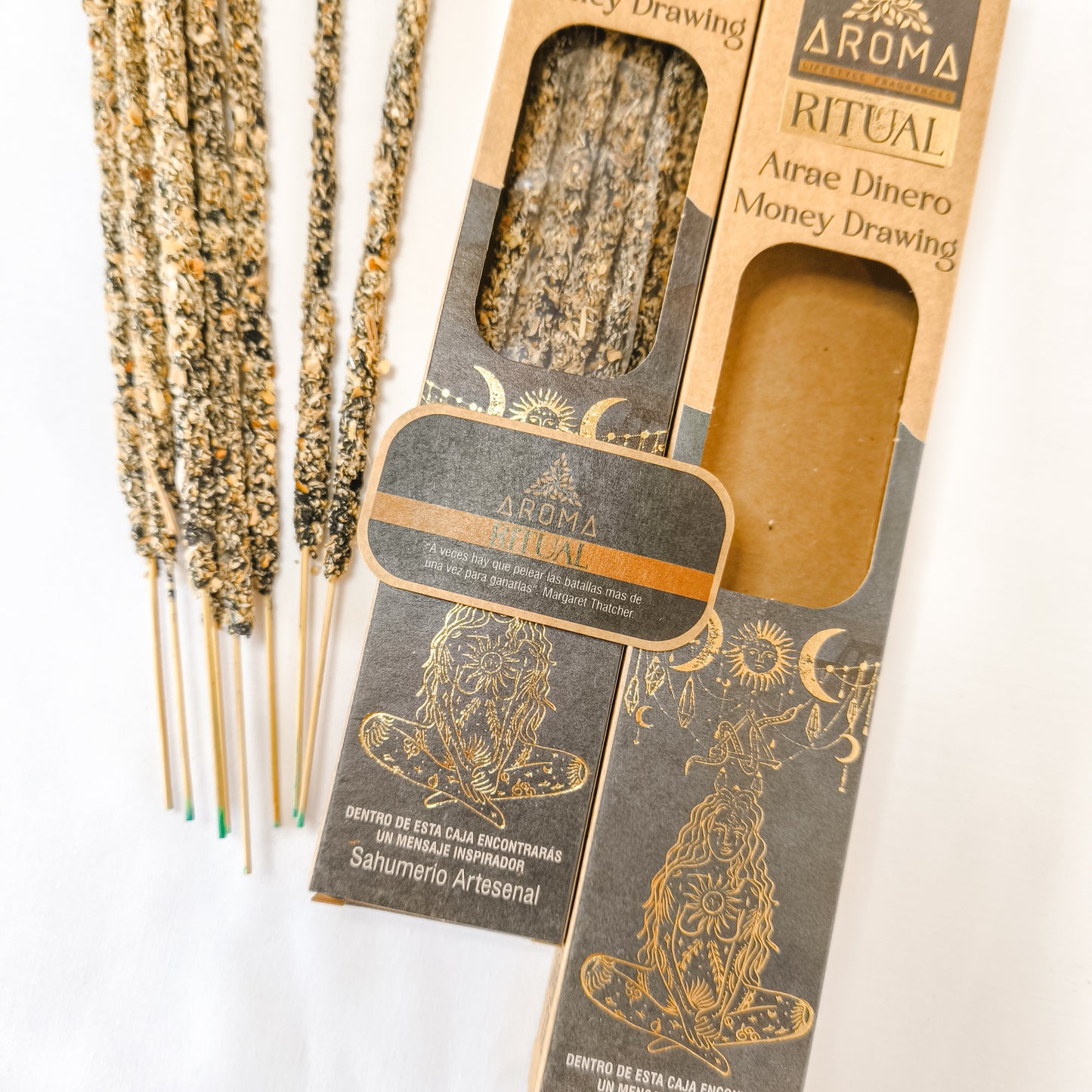 Incienso artesanal y orgánico, con el texto "Incienso Ritual Atrae Dinero" visible en el empaque. El humo se eleva suavemente.