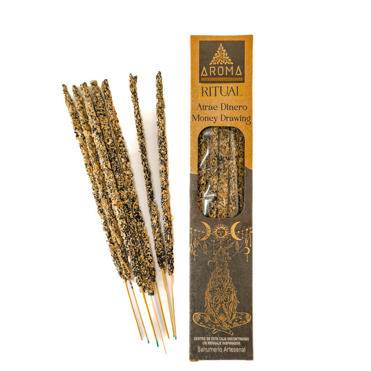 Incienso artesanal y orgánico, con el texto "Incienso Ritual Atrae Dinero" visible en el empaque. El humo se eleva suavemente.